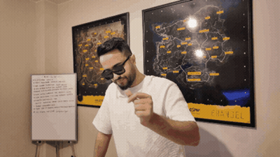 A Man Wearing Sunglasses And A White Shirt Stands In Front Of A Map That Says ' Battlefield ' GIF