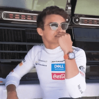 A Man Wearing Sunglasses And A White Shirt With A Dell And Coca Cola Logo On It Is Sitting In A Garage . GIF