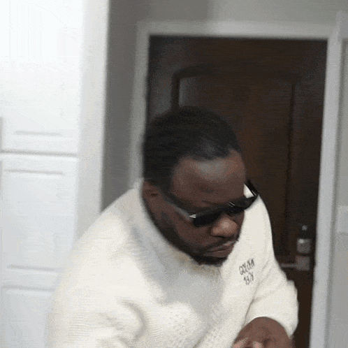 A Man Wearing Sunglasses And A White Sweater Has The Word Groom On The Front GIF