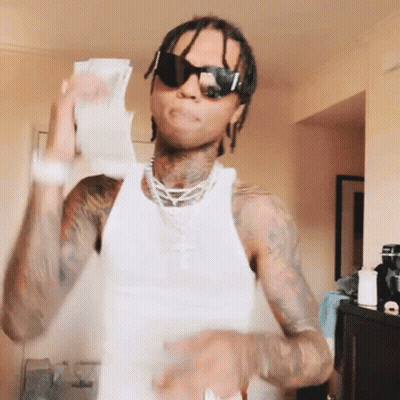A Man Wearing Sunglasses And A White Tank Top Is Holding Up A Bunch Of Money GIF