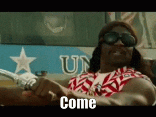 A Man Wearing Sunglasses And A Wig Is Driving A Motorcycle And The Words Come Are On The Screen . GIF