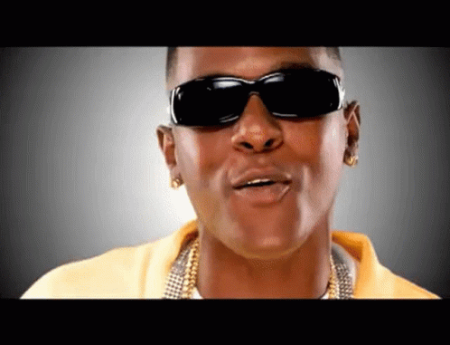 A Man Wearing Sunglasses And A Yellow Shirt Is Making A Funny Face GIF