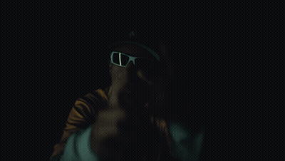 A Man Wearing Sunglasses And A Yellow Shirt With Bape On It GIF