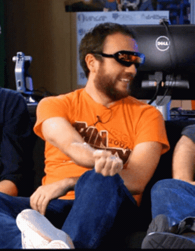 A Man Wearing Sunglasses And An Orange Shirt Sitting In Front Of A Dell Monitor GIF