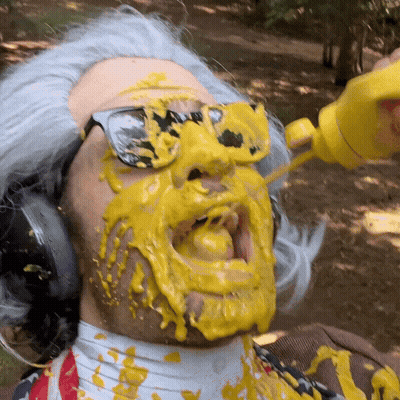 A Man Wearing Sunglasses And Headphones Is Covered In Yellow Liquid GIF