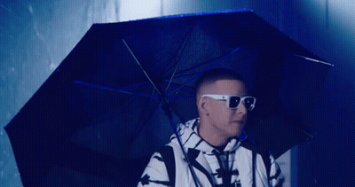 A Man Wearing Sunglasses And Holding An Umbrella GIF
