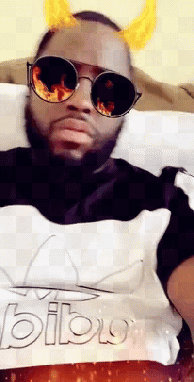 A Man Wearing Sunglasses And Horns Is Laying On A Bed GIF