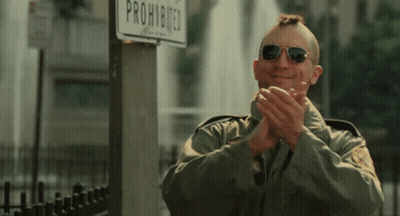 A Man Wearing Sunglasses Applauds In Front Of A Sign That Says Prohibited GIF