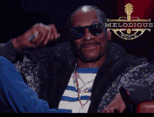 A Man Wearing Sunglasses Holds A Microphone And Says Keren Suaranya In White Letters GIF