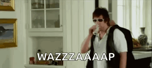 A Man Wearing Sunglasses Is Drinking A Glass Of Milk In A Kitchen . GIF