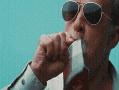 A Man Wearing Sunglasses Is Drinking From A Glass Of Beer . GIF