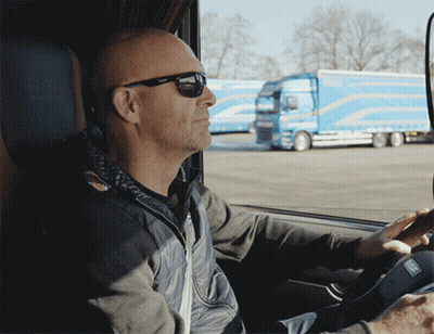 A Man Wearing Sunglasses Is Driving A Car GIF