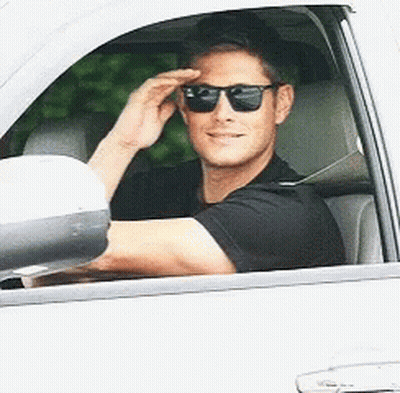 A Man Wearing Sunglasses Is Driving A Car GIF