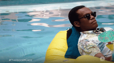 A Man Wearing Sunglasses Is Floating In A Swimming Pool With A Nbc Logo In The Background GIF