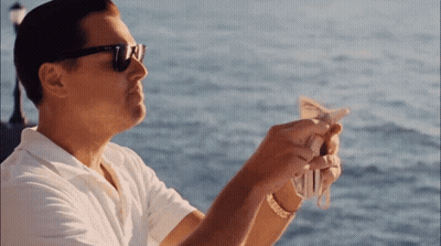 A Man Wearing Sunglasses Is Holding A Bunch Of Money In His Hands GIF