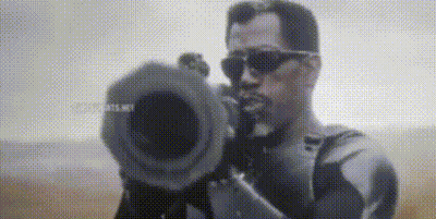 A Man Wearing Sunglasses Is Holding A Camera In His Hand And Pointing It At The Camera . GIF