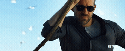 A Man Wearing Sunglasses Is Holding A Cane In Front Of A Blue Sky GIF
