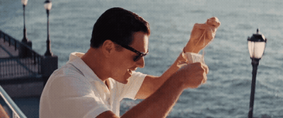 A Man Wearing Sunglasses Is Holding A Piece Of Paper In Front Of The Ocean GIF