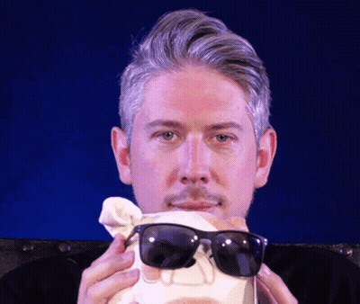 A Man Wearing Sunglasses Is Holding A Skull In His Hands GIF