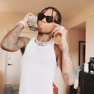A Man Wearing Sunglasses Is Holding A Stack Of Money In His Hand GIF