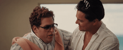 A Man Wearing Sunglasses Is Holding Another Man In His Arms GIF