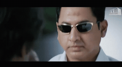 A Man Wearing Sunglasses Is Looking At Another Man 'S Face GIF