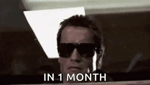 A Man Wearing Sunglasses Is Looking Out A Window With The Words `` In 1 Month '' Written On It . GIF