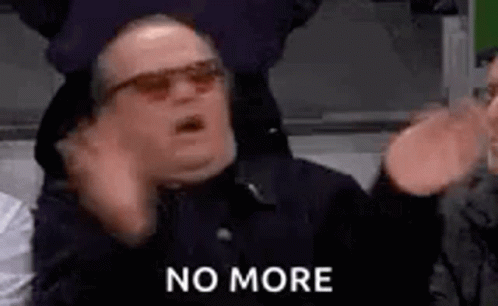 A Man Wearing Sunglasses Is Making A Funny Face And Saying `` No More '' While Sitting In A Stadium . GIF