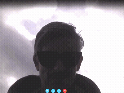 A Man Wearing Sunglasses Is On A Video Call With Three Blue Buttons GIF