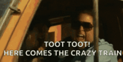 A Man Wearing Sunglasses Is Screaming Out Of A Car Window . GIF