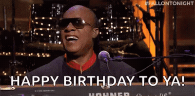 A Man Wearing Sunglasses Is Singing Into A Microphone And Saying `` Happy Birthday To Ya '' . GIF
