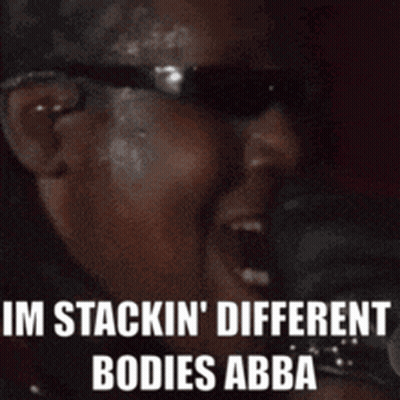 A Man Wearing Sunglasses Is Singing Into A Microphone And Says I 'M Stackin ' Different Bodies Abba . GIF