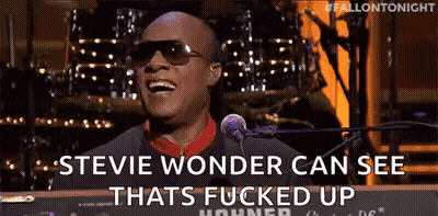 A Man Wearing Sunglasses Is Singing Into A Microphone While Playing A Keyboard . GIF