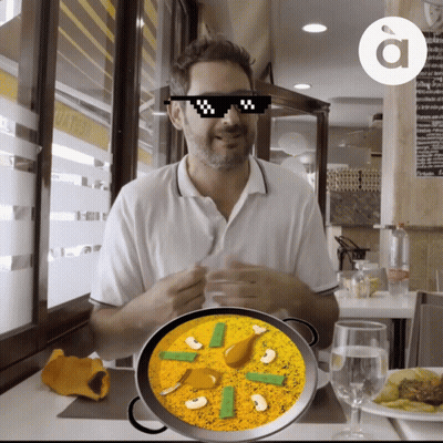 A Man Wearing Sunglasses Is Sitting At A Table With A Bowl Of Food GIF