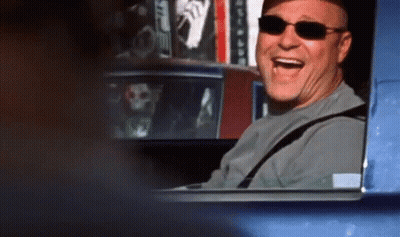 A Man Wearing Sunglasses Is Sitting In A Car And Laughing GIF
