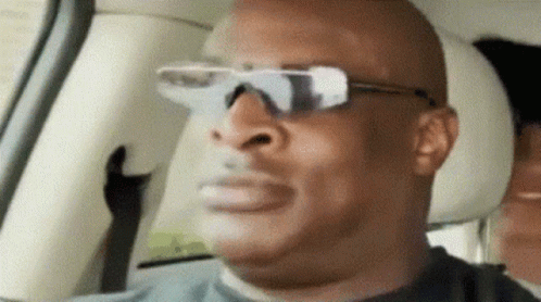 A Man Wearing Sunglasses Is Sitting In A Car GIF