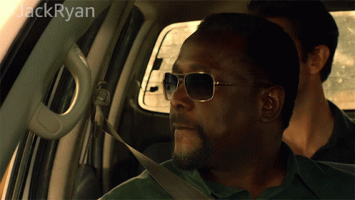 A Man Wearing Sunglasses Is Sitting In A Car With The Name Jack Ryan On The Bottom GIF