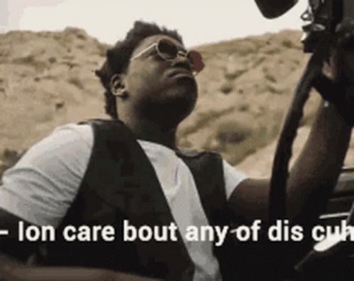A Man Wearing Sunglasses Is Sitting In A Car With The Words " Ion Care Bout Any Of Dis Cu " Written Below Him GIF