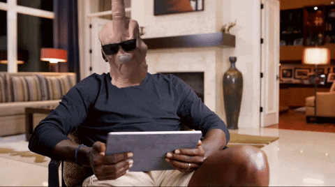 A Man Wearing Sunglasses Is Sitting In A Chair Holding A Tablet GIF