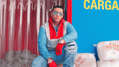 A Man Wearing Sunglasses Is Sitting On Top Of A Pile Of Top Secret Bags GIF