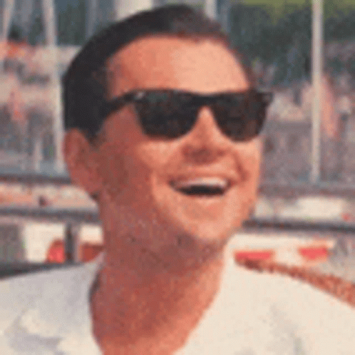 A Man Wearing Sunglasses Is Smiling In A Close Up Of His Face . GIF