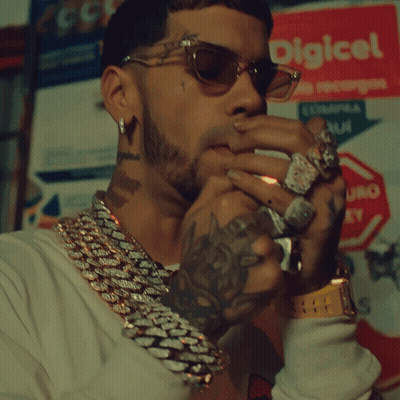 A Man Wearing Sunglasses Is Smoking A Cigar In Front Of A Sign That Says Digical GIF