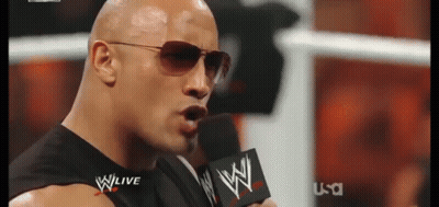 A Man Wearing Sunglasses Is Speaking Into A Microphone With The Word Wwe On It GIF