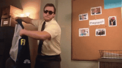 A Man Wearing Sunglasses Is Standing In Front Of A Bulletin Board That Says " Pregnant " GIF