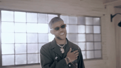 A Man Wearing Sunglasses Is Standing In Front Of A Window And Smiling GIF