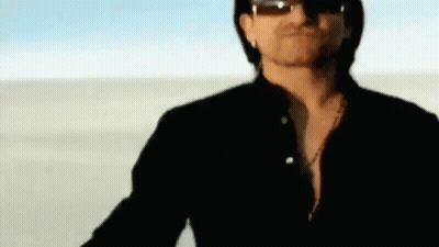 A Man Wearing Sunglasses Is Standing In The Desert . GIF