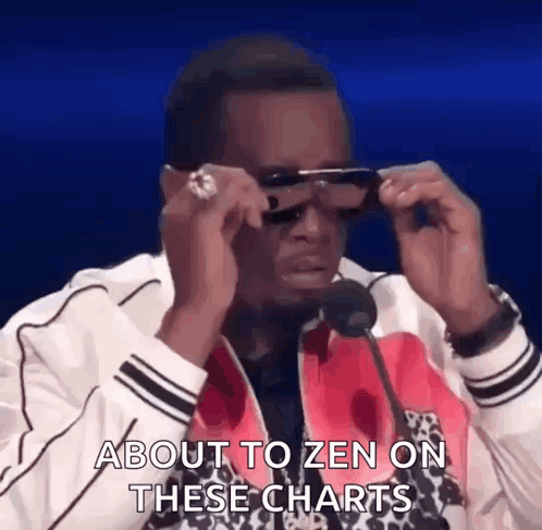 A Man Wearing Sunglasses Is Talking Into A Microphone . GIF