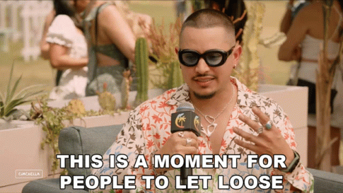 A Man Wearing Sunglasses Is Talking Into A Microphone With The Words " This Is A Moment For People To Let Loose " Below  GIF
