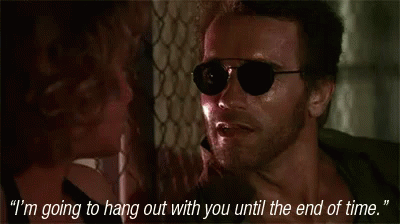 A Man Wearing Sunglasses Is Talking To A Woman Who Is Holding His Neck GIF