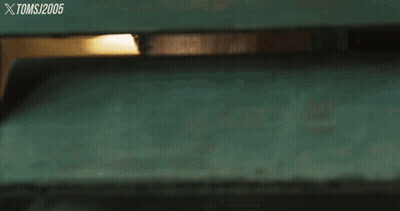 A Man Wearing Sunglasses Looks Through A Green Fence With The Year 2005 On The Bottom Right GIF